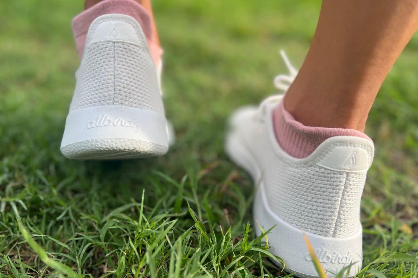 Anna in Allbirds Tree Runners shoes walking on the grass